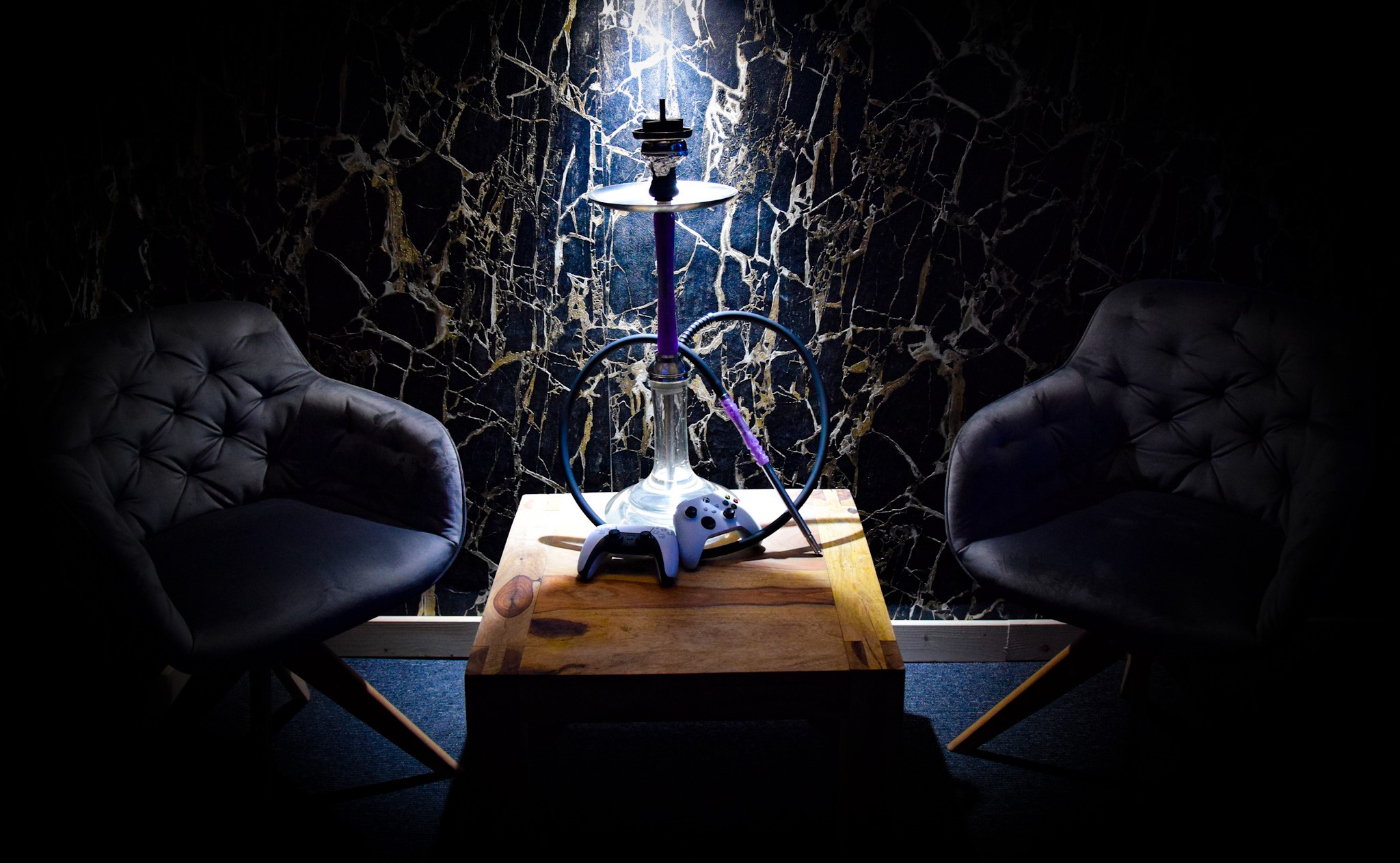Stůl s vodní dýmkou a herními ovladači v Golden&Black Benešov